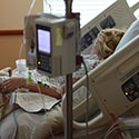 Woman sleeps in a hospital bed.