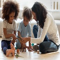 Babysitter playing with toys with two young children